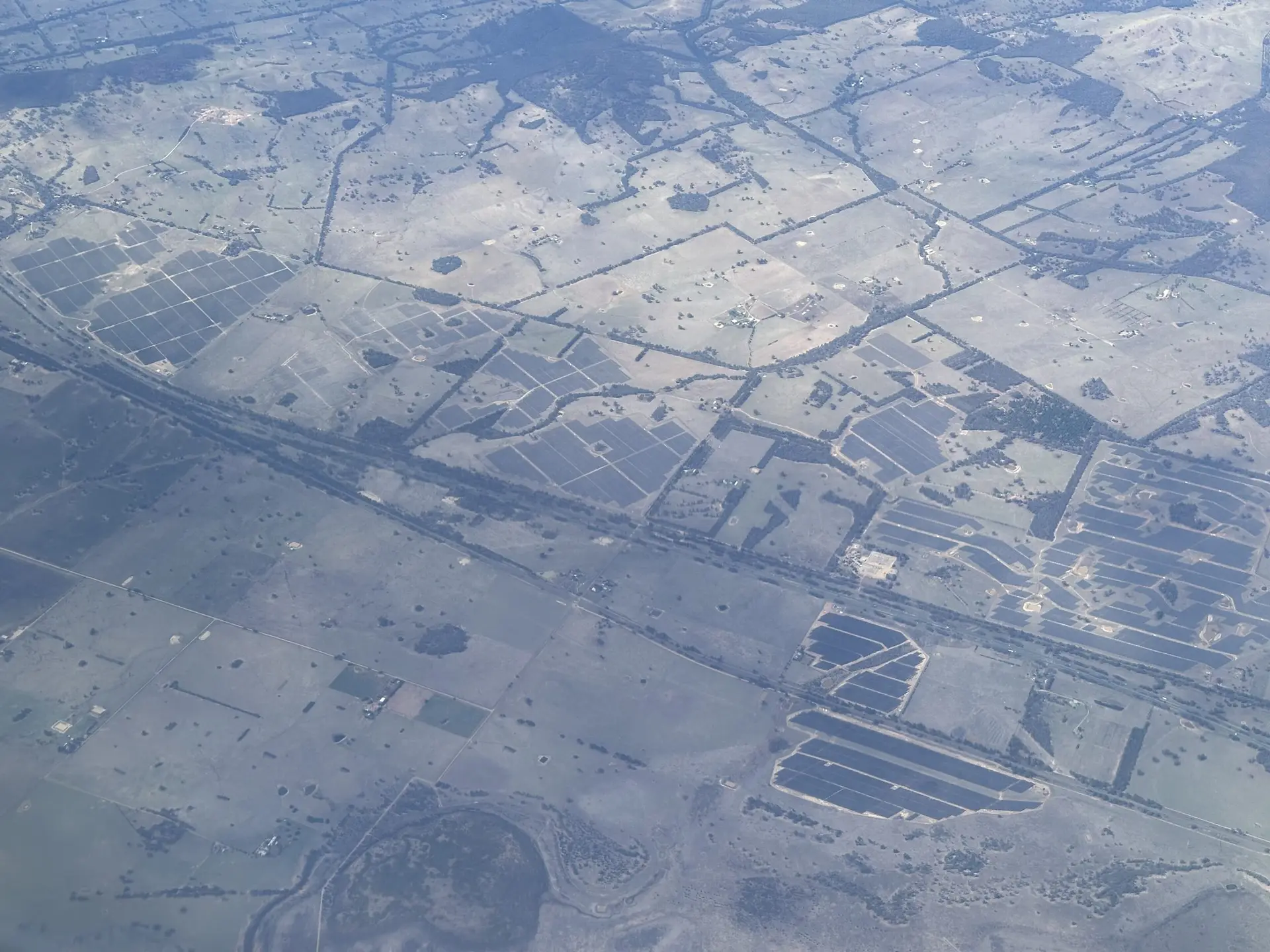 Aerial view of solar farms across open farmland