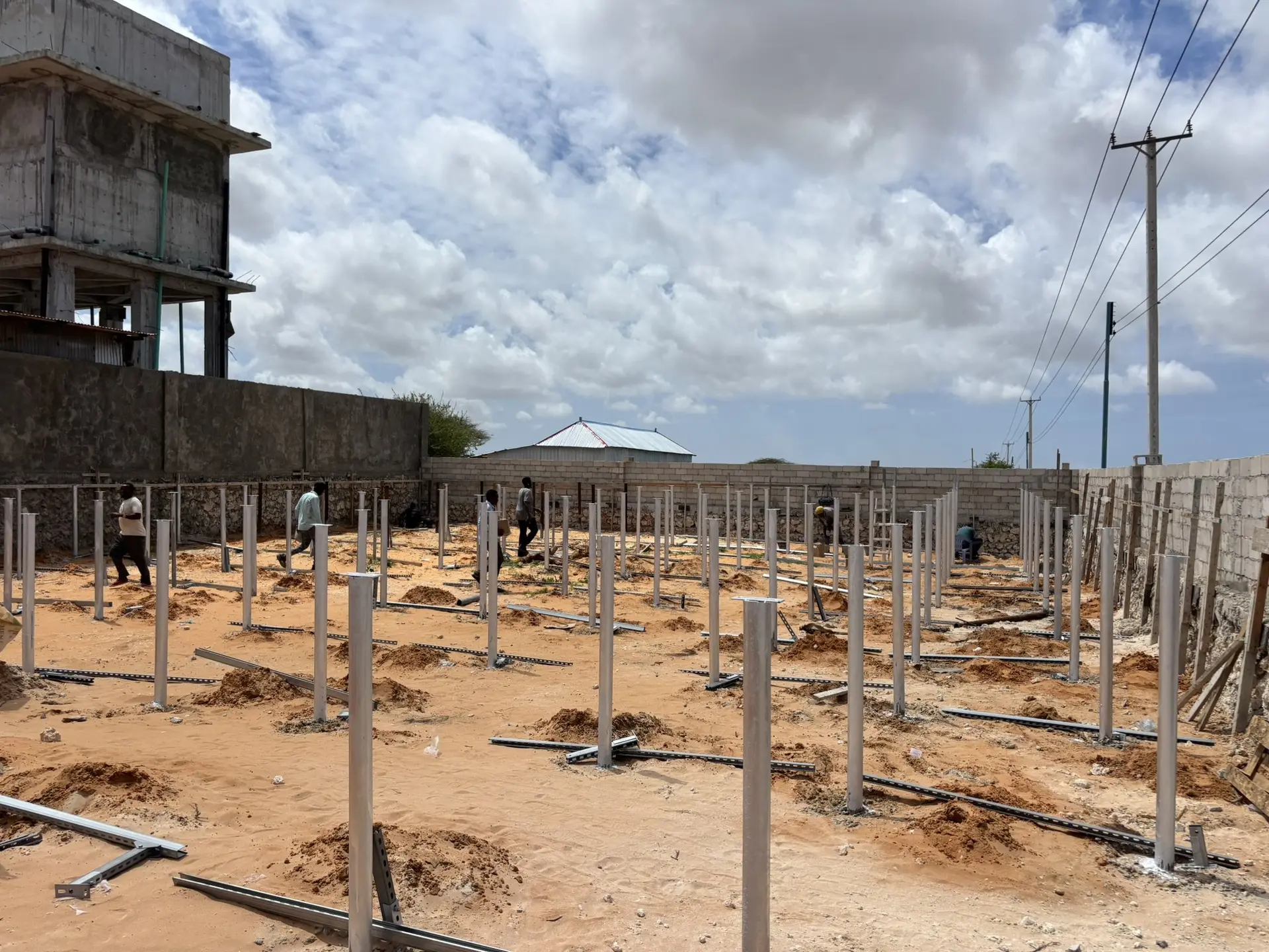 Solar mounting piles at a water site with a water tower behind