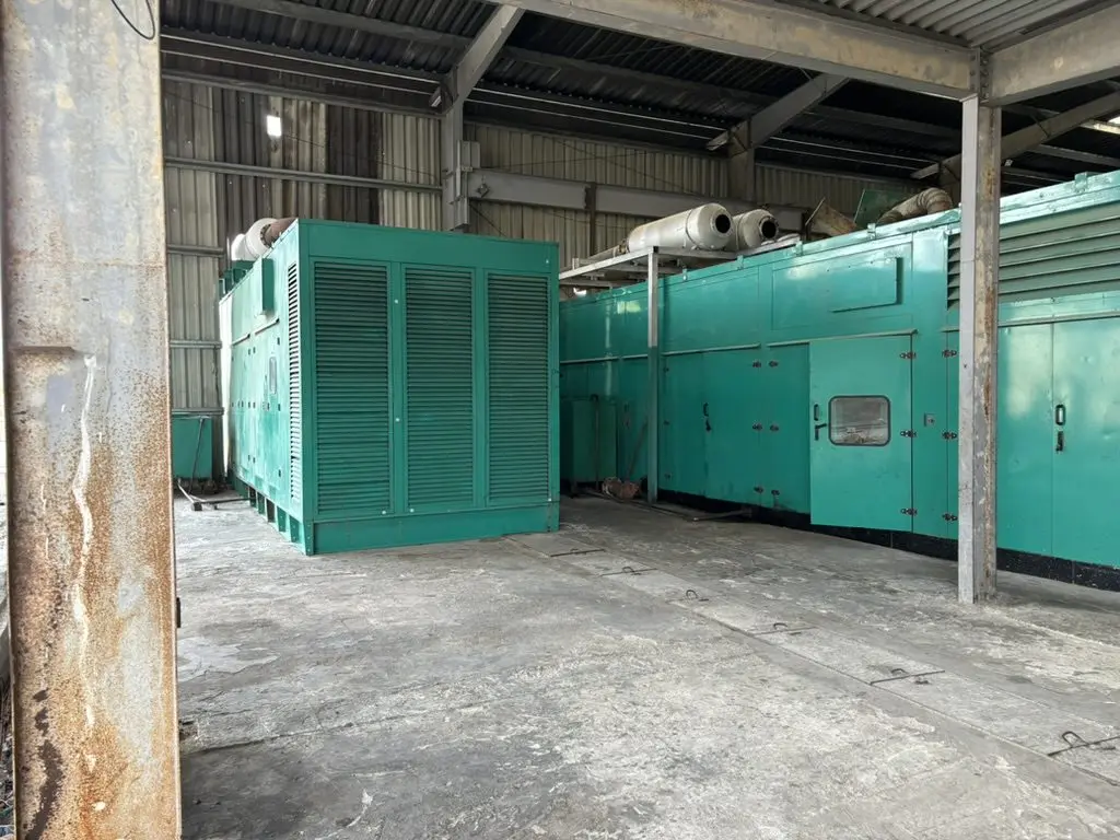 Generator sets in green enclosures inside a power station hall