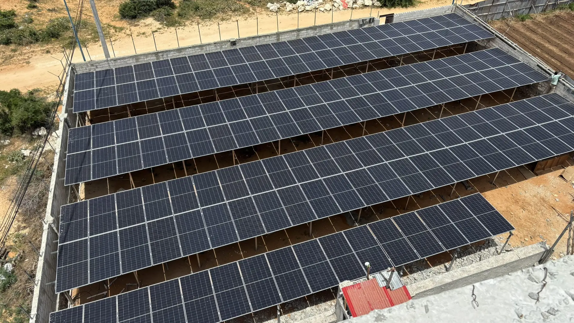 Rows of solar panels on a flat roof, seen from above